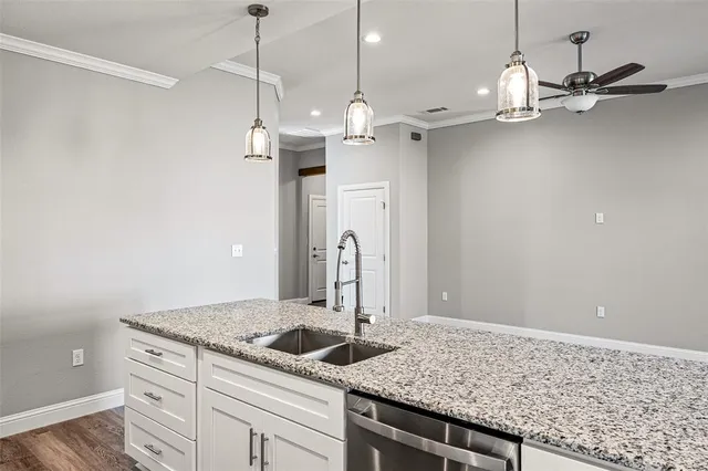 a kitchen with kitchen island granite countertop a sink a refrigerator and chandelier