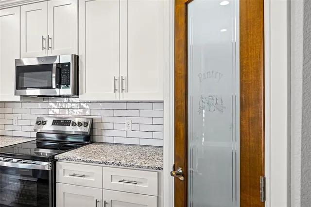 a kitchen with stainless steel appliances granite countertop white cabinets and black appliances