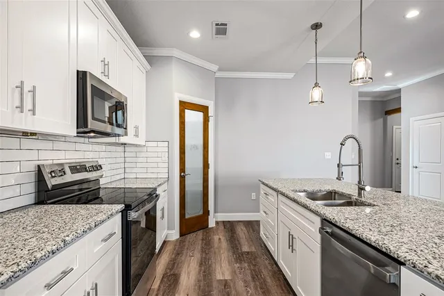 a kitchen with stainless steel appliances granite countertop a sink stove and refrigerator
