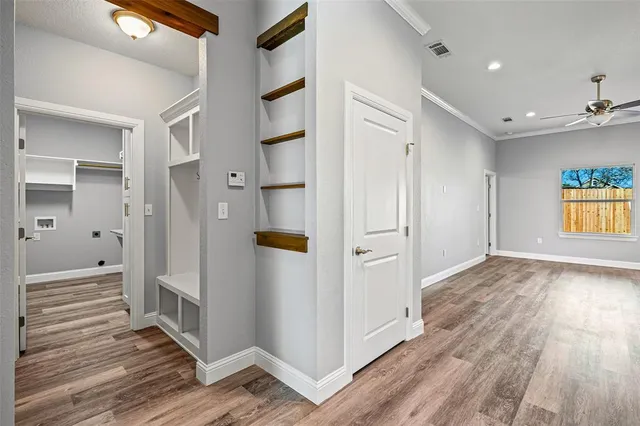 a view of a hallway with wooden floor and windows
