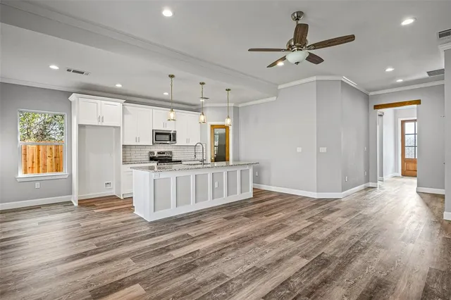 a view of kitchen with refrigerator microwave and stove with wooden floor