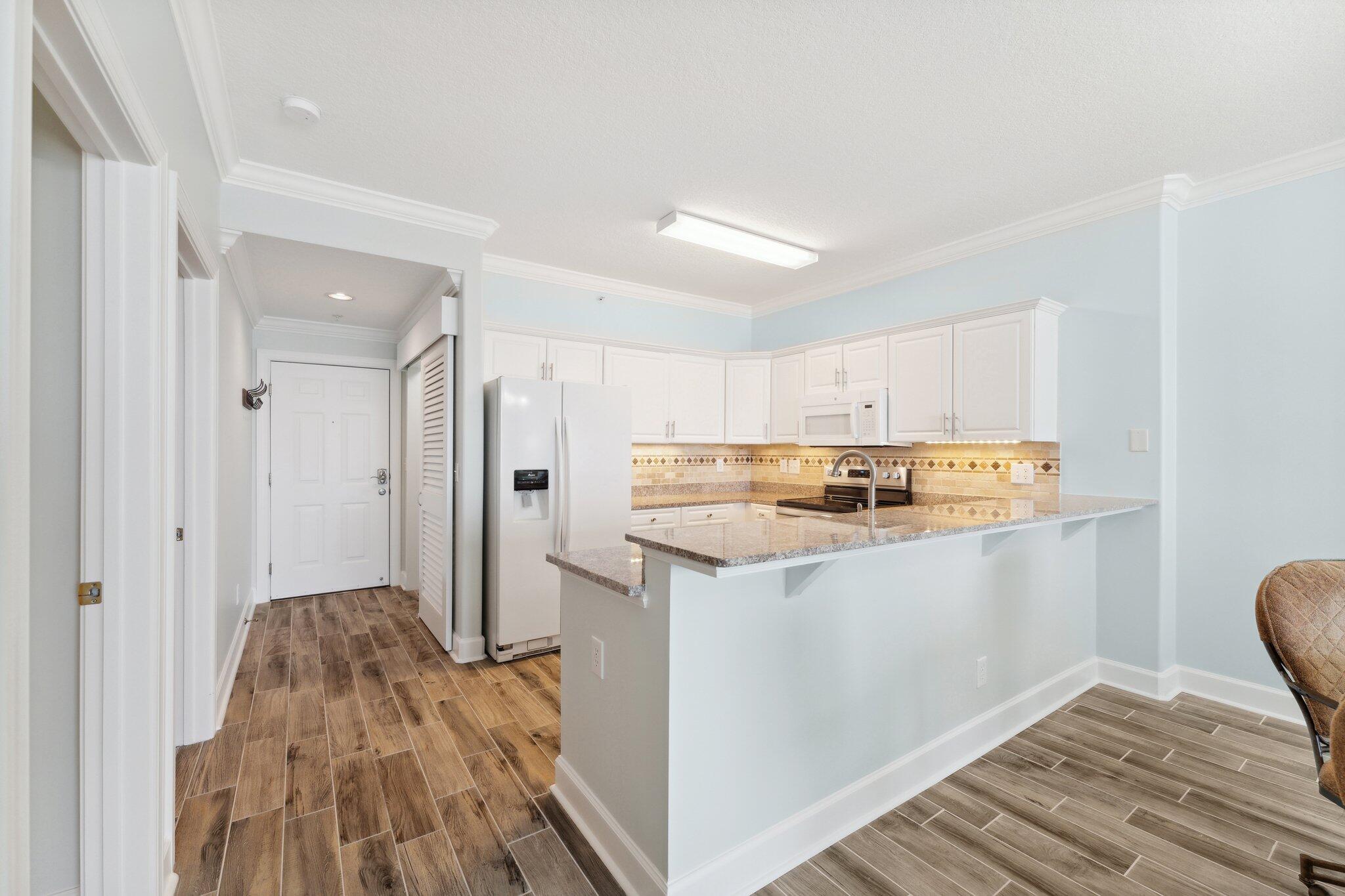 17545 Front Beach Road, Unit 2103 Panama City Beach, FL 32413 - Photo 10 of 56 a kitchen with stainless steel appliances a refrigerator and a stove
