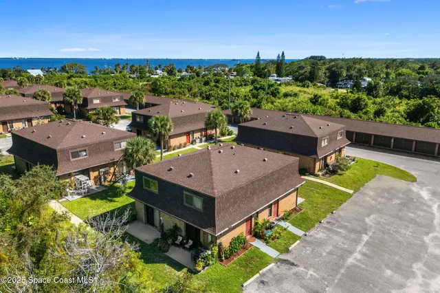 an aerial view of a house with a garden and lake view