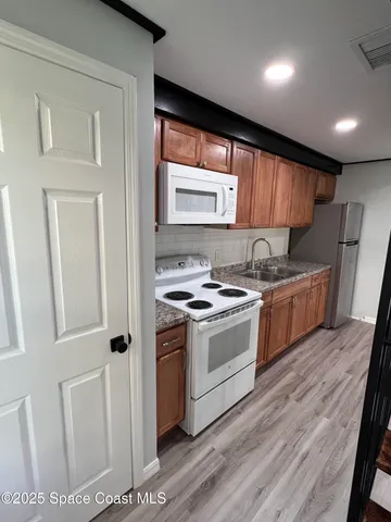 a kitchen with a stove a sink and a refrigerator