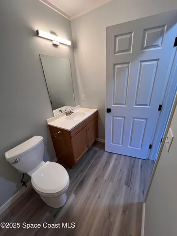 a bathroom with a toilet a sink a mirror and vanity