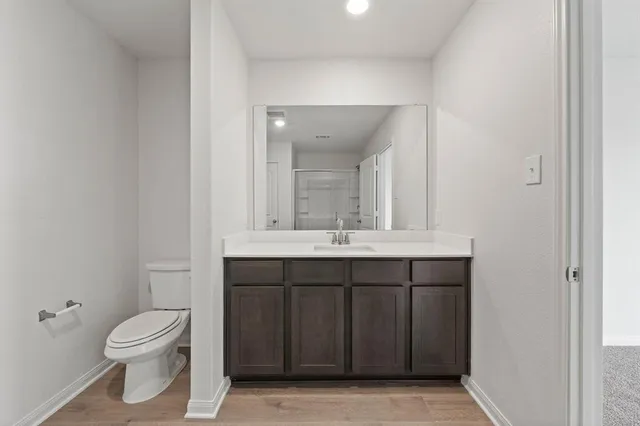 a bathroom with a granite countertop toilet a sink and a mirror