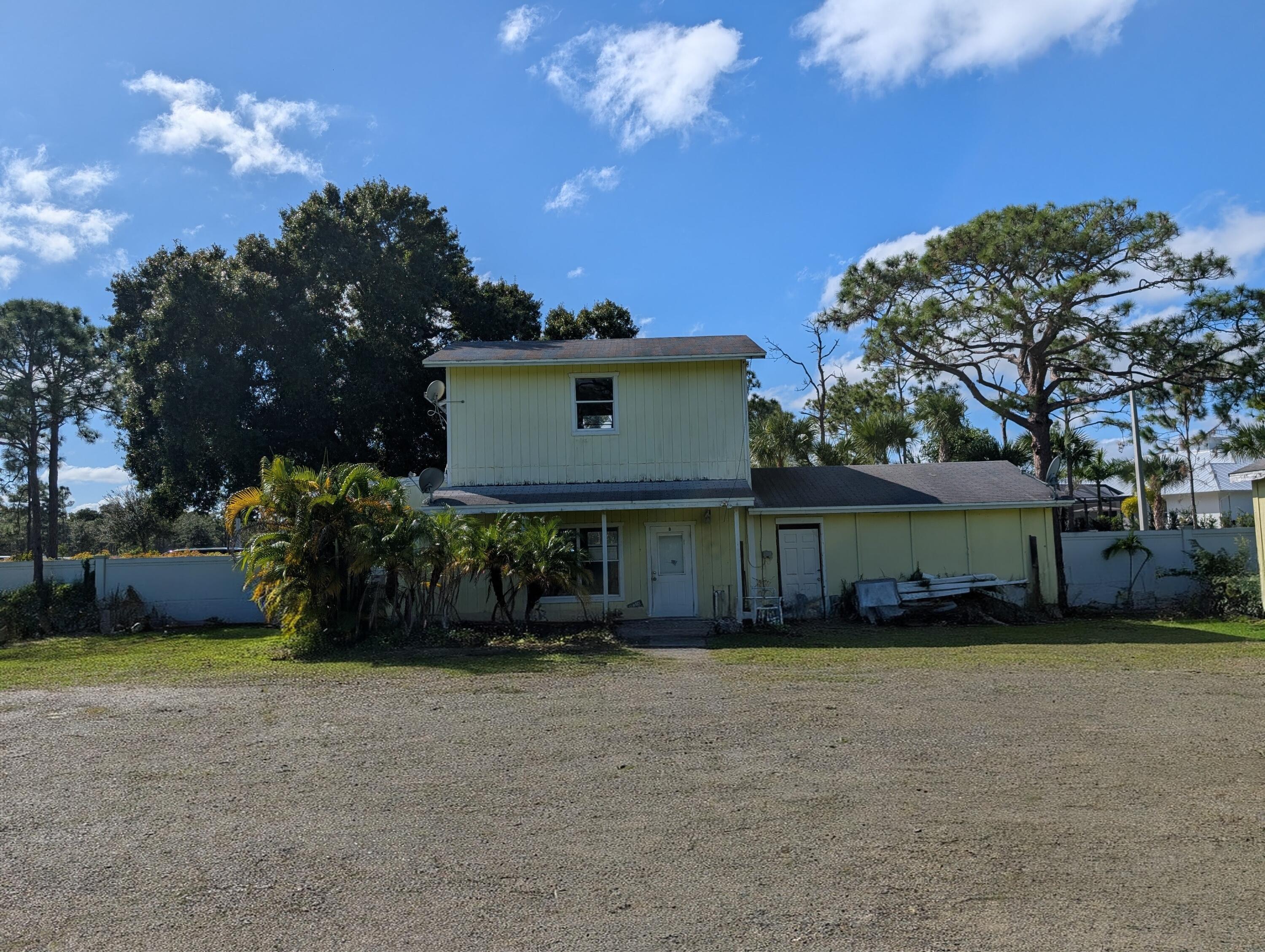 1500 Southeast Cove Road Stuart, FL 34997 - Photo 16 of 28 a view of a house with a yard and a large tree