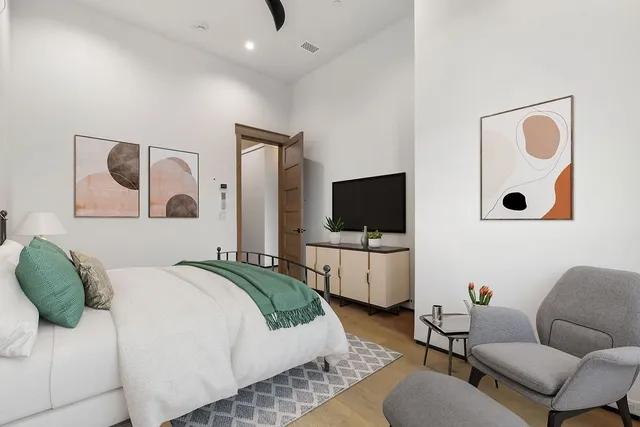 a bedroom with a bed couch and flat screen tv