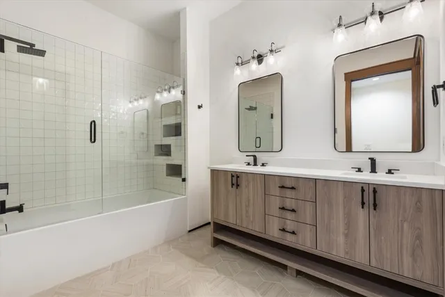 a bathroom with double vanity sinks and a bathtub