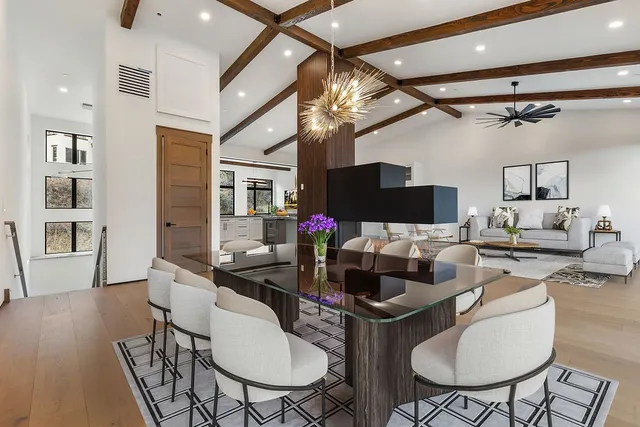 a living room with furniture a flat screen tv and kitchen view