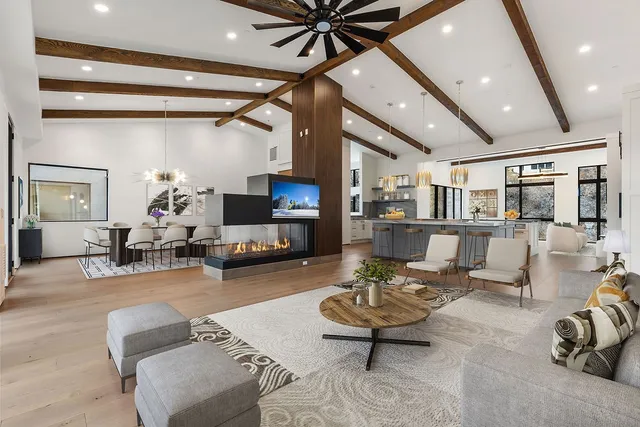 a living room with furniture a flat screen tv and a table