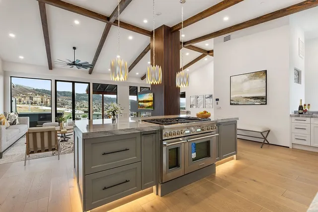 a kitchen with stainless steel appliances granite countertop a stove and a view of living room