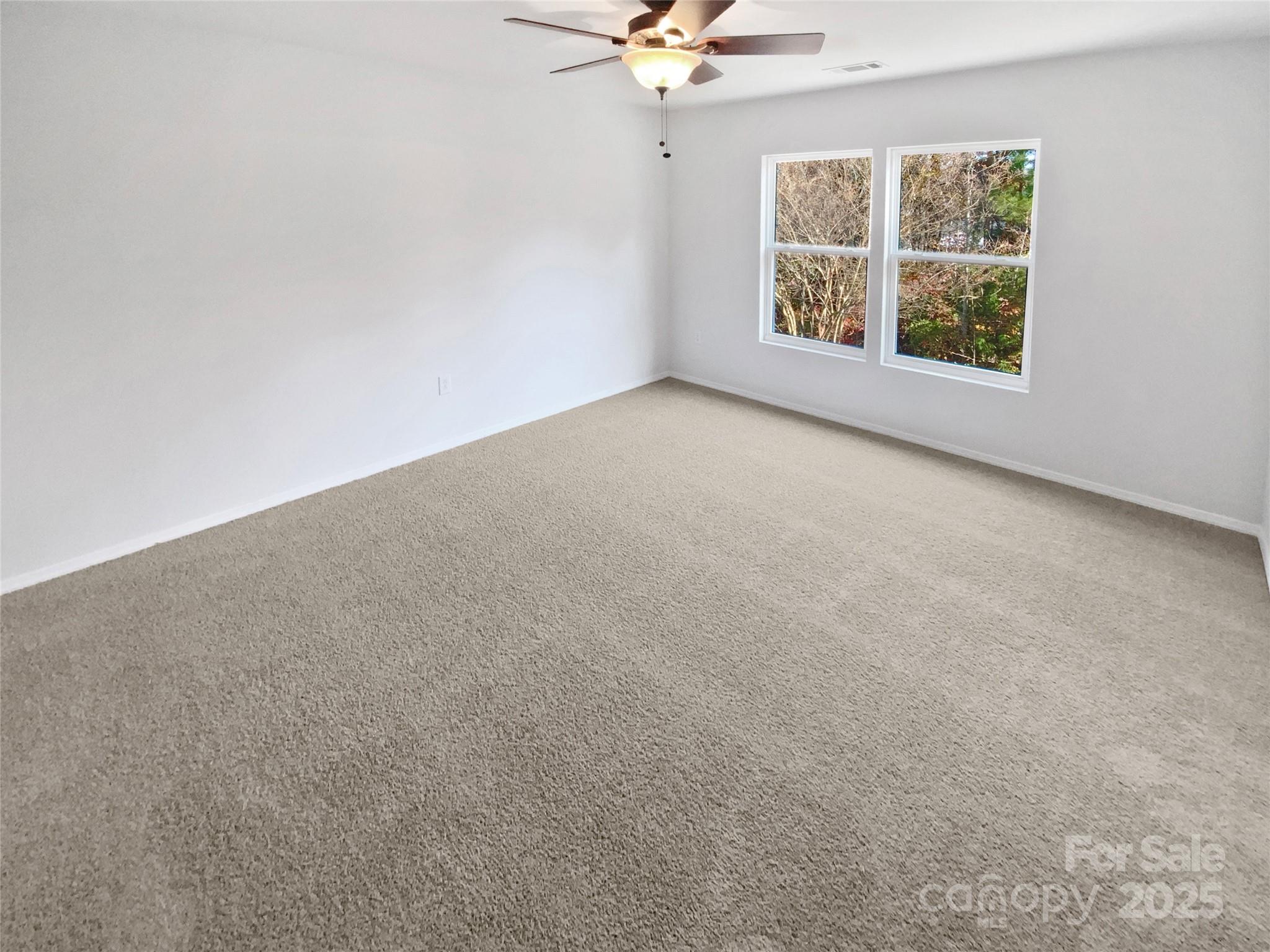 4418 Kiddle Lane Monroe, NC 28110 - Photo 16 of 19 an empty room with windows and fan