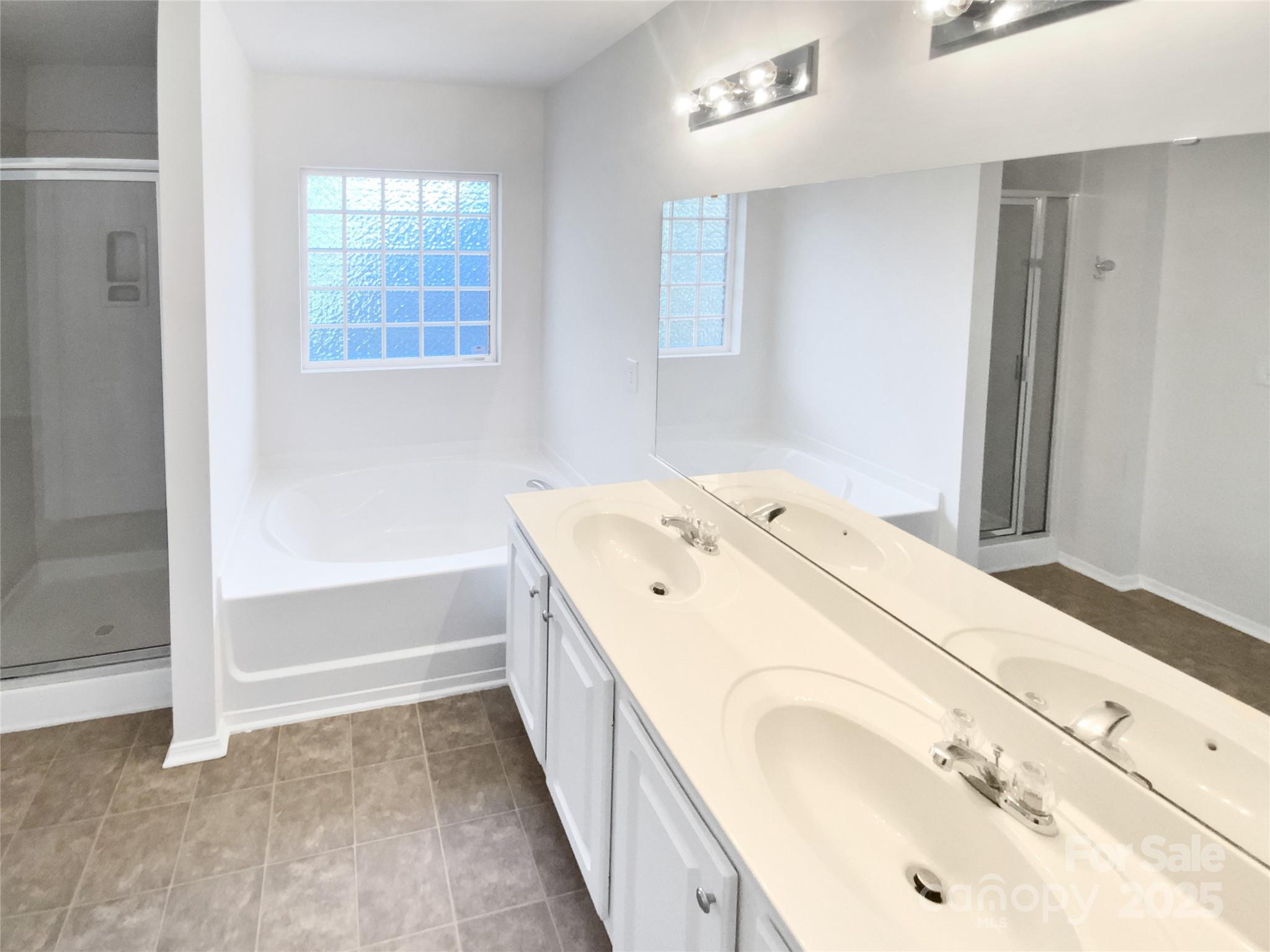 4418 Kiddle Lane Monroe, NC 28110 - Photo 6 of 19 a spacious bathroom with a tub sink and a mirror