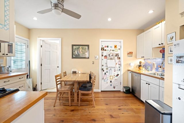 a kitchen with stainless steel appliances kitchen island granite countertop a table and chairs in it