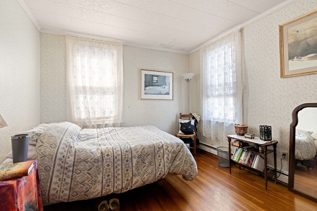 59 7th Street Cambridge, MA 02141 - Photo 8 of 26 a bedroom with a bed a dresser and a window