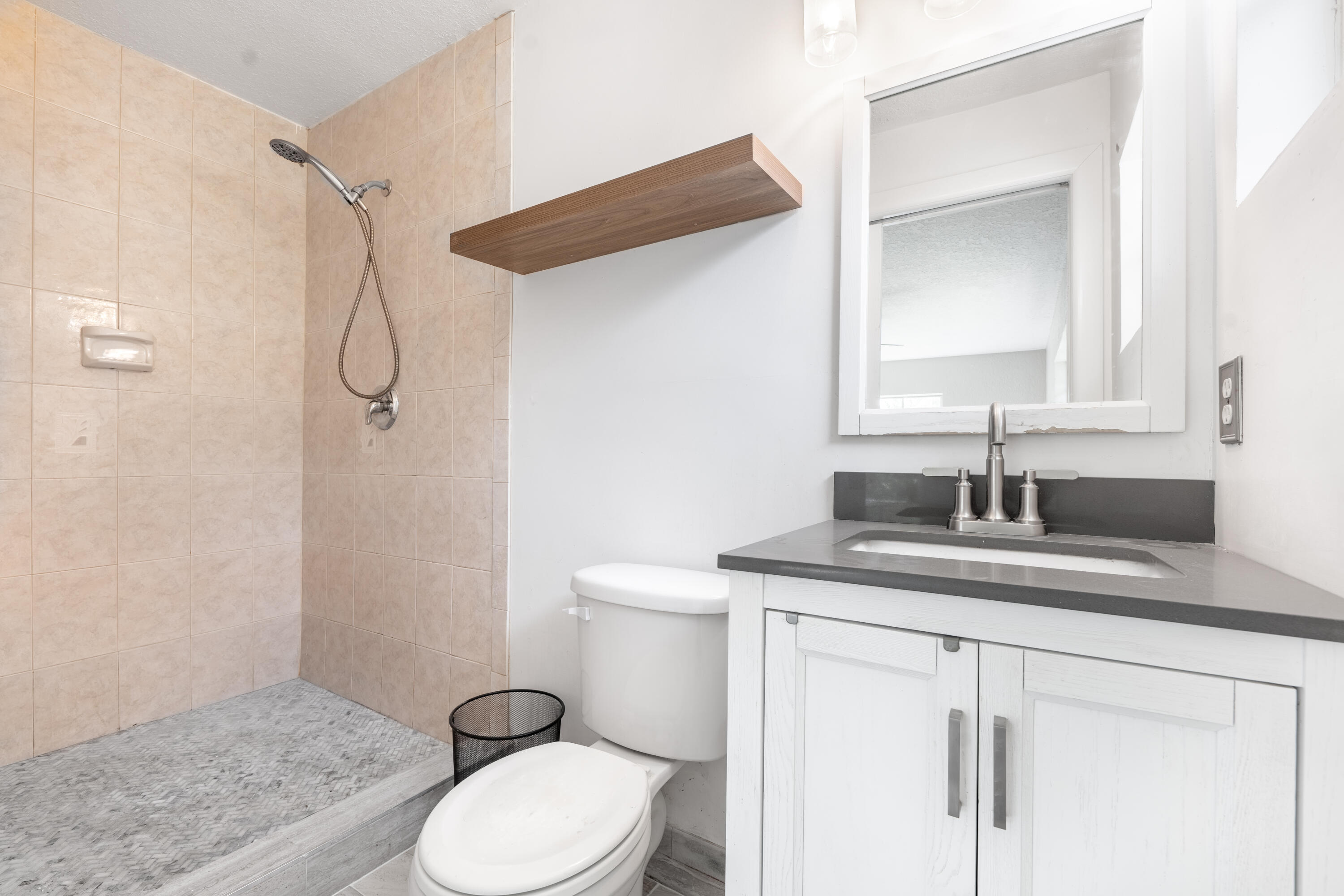 1219 South 10th Street Fort Pierce, FL 34950 - Photo 7 of 29 a bathroom with a granite countertop sink toilet and mirror