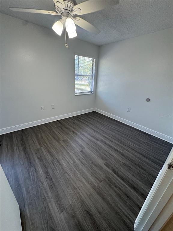1197 Bentley Road, Unit 3 Leesburg, FL 34748 - Photo 12 of 13 an empty room with wooden floor windows and fan