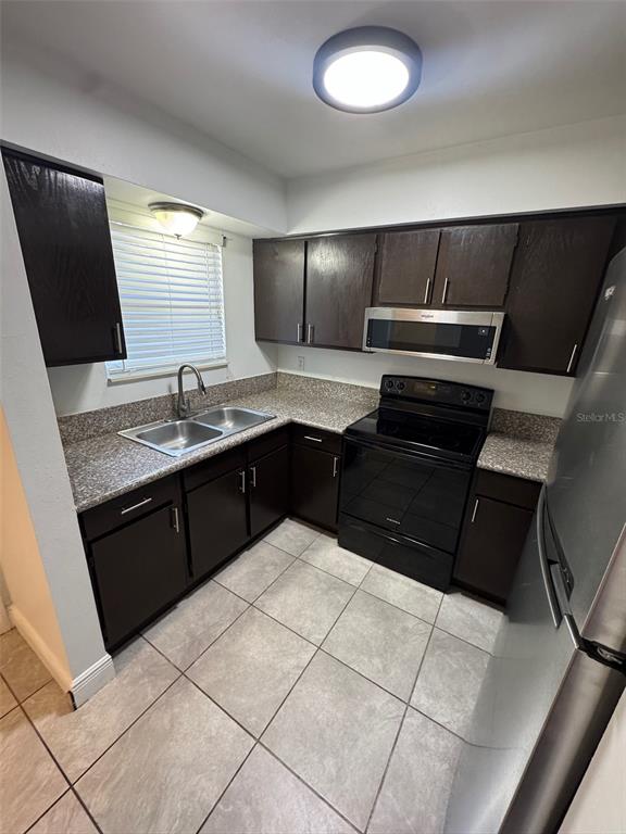 1197 Bentley Road, Unit 3 Leesburg, FL 34748 - Photo 3 of 13 a kitchen with a sink and a refrigerator