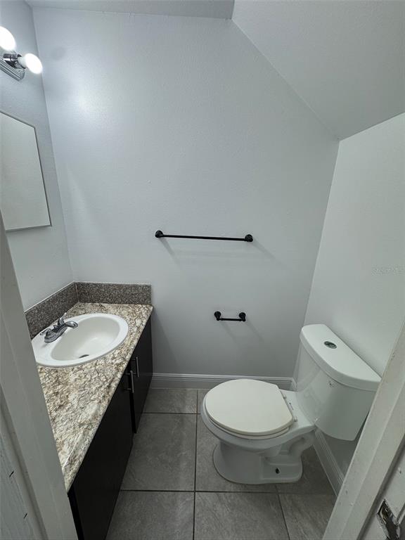 1197 Bentley Road, Unit 3 Leesburg, FL 34748 - Photo 7 of 13 a bathroom with a granite countertop sink a toilet and a mirror