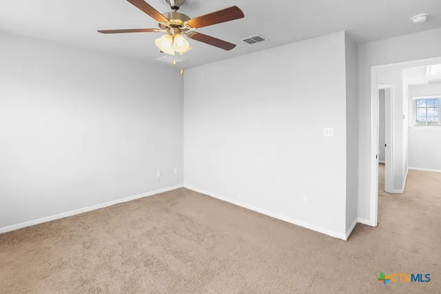 an empty room with a fan and a fan
