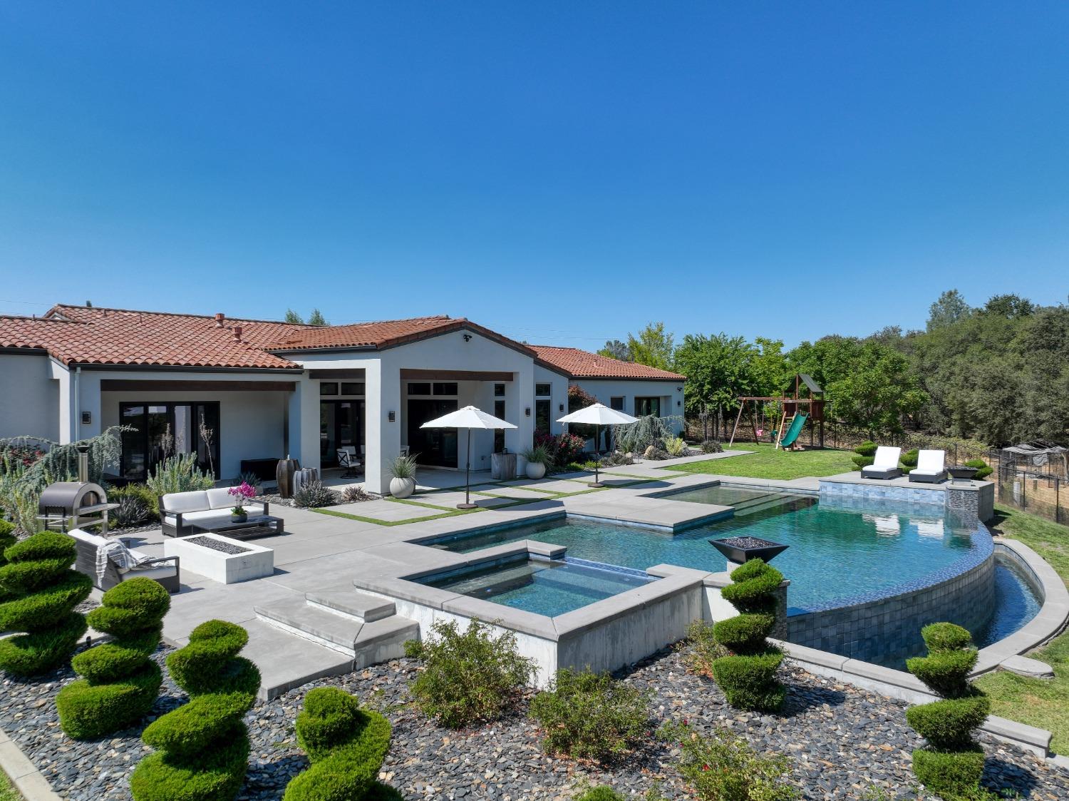 a view of a house with swimming pool and sitting area