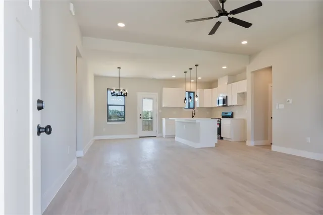 a view of a kitchen with a sink and dishwasher a refrigerator with wooden floor