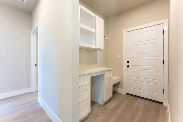 a view of an empty room with cabinet and a kitchen