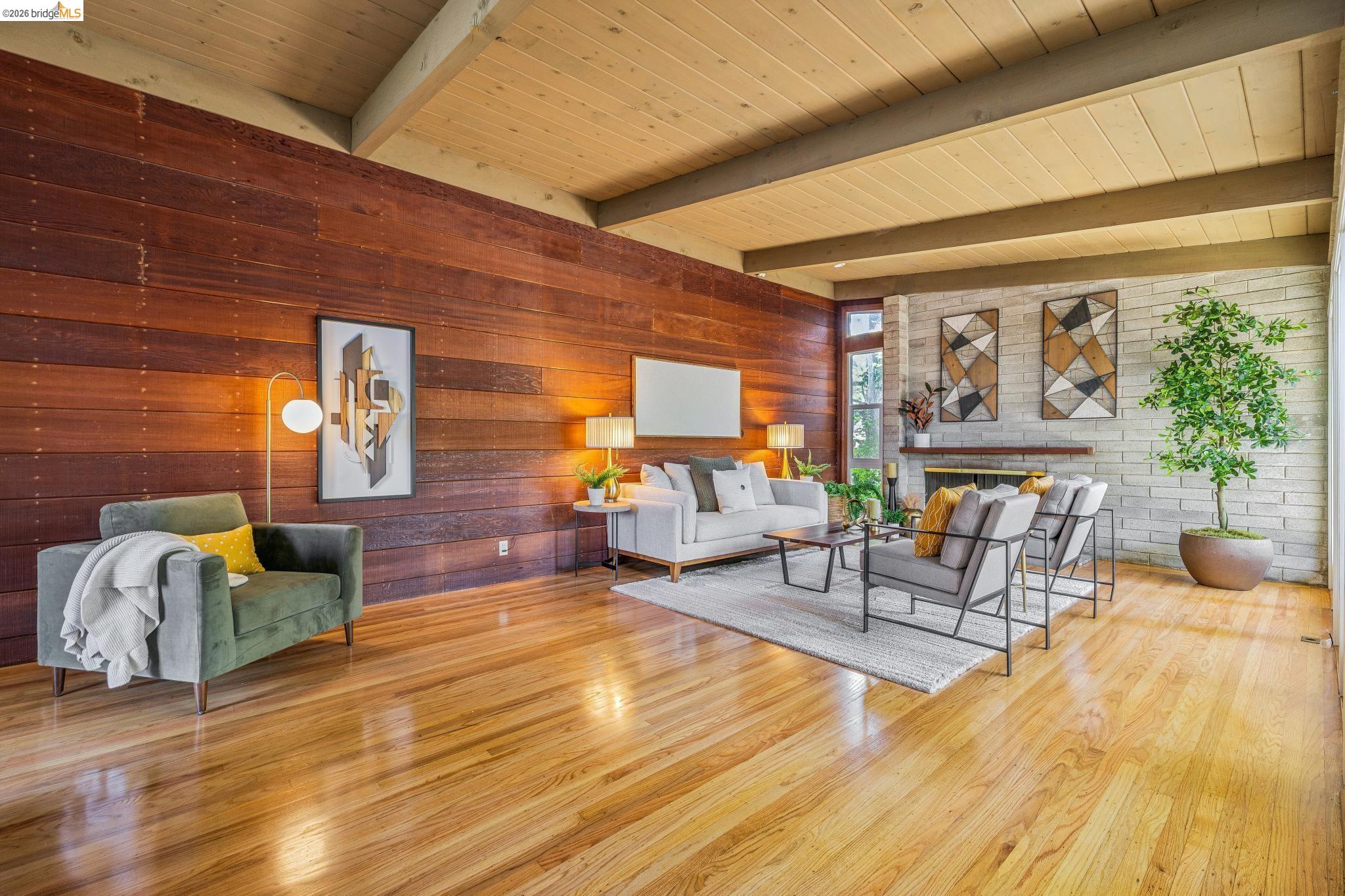 1024 Overlook Road Berkeley, CA 94708 - Photo 15 of 41 Vaulted wood-paneled ceiling with exposed beams, wood-finish flooring, full-height wood-paneled accent wall, and a stone-clad fireplace
