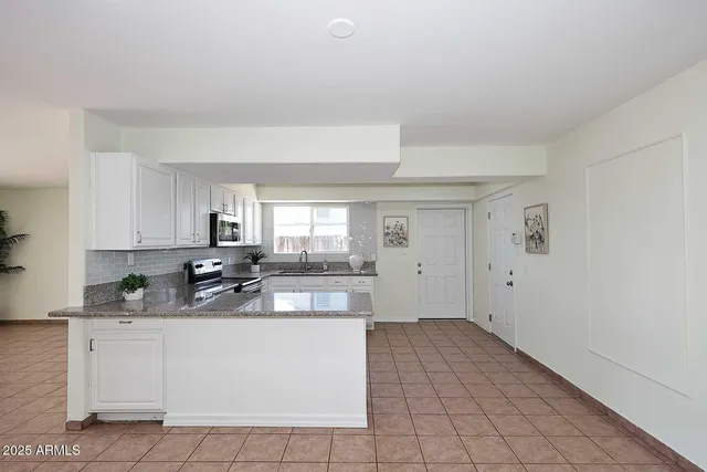 a kitchen with white cabinets a sink and dishwasher