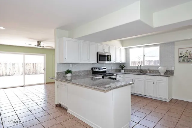 a kitchen with stainless steel appliances granite countertop a stove a sink a microwave and cabinets