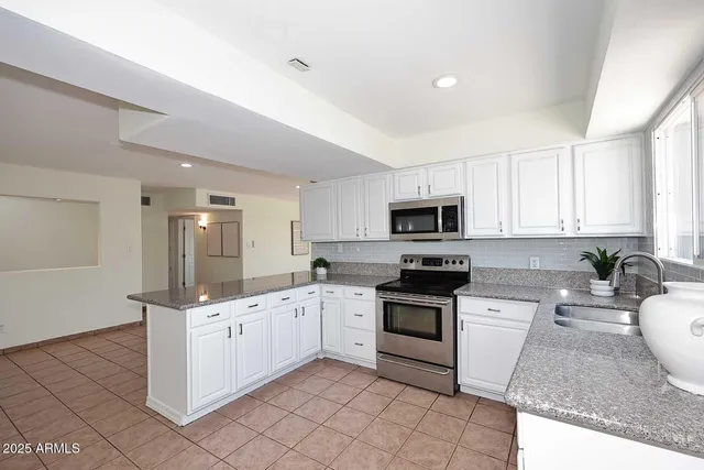 a kitchen with sink a microwave and cabinets