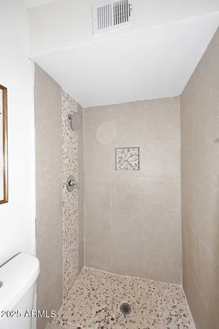 a bathroom with a toilet and a shower