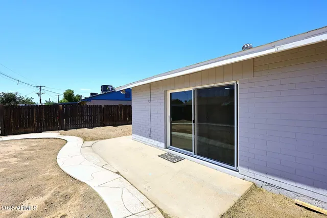 a view of backyard with small space and wooden fence