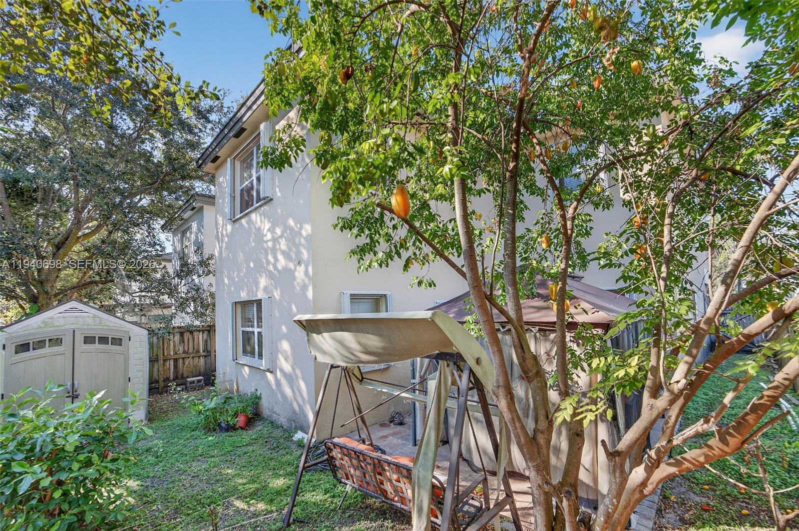 367 Northeast 36th Avenue Road Homestead, FL 33033 - Photo 30 of 36 a view of a white house next to a yard with plants and trees
