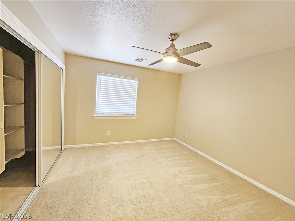 4591 Stoneham Street Pahrump, NV 89061 - Photo 35 of 42 A comfortable bedroom with a generous closet and an overhead light with an integrated fan.