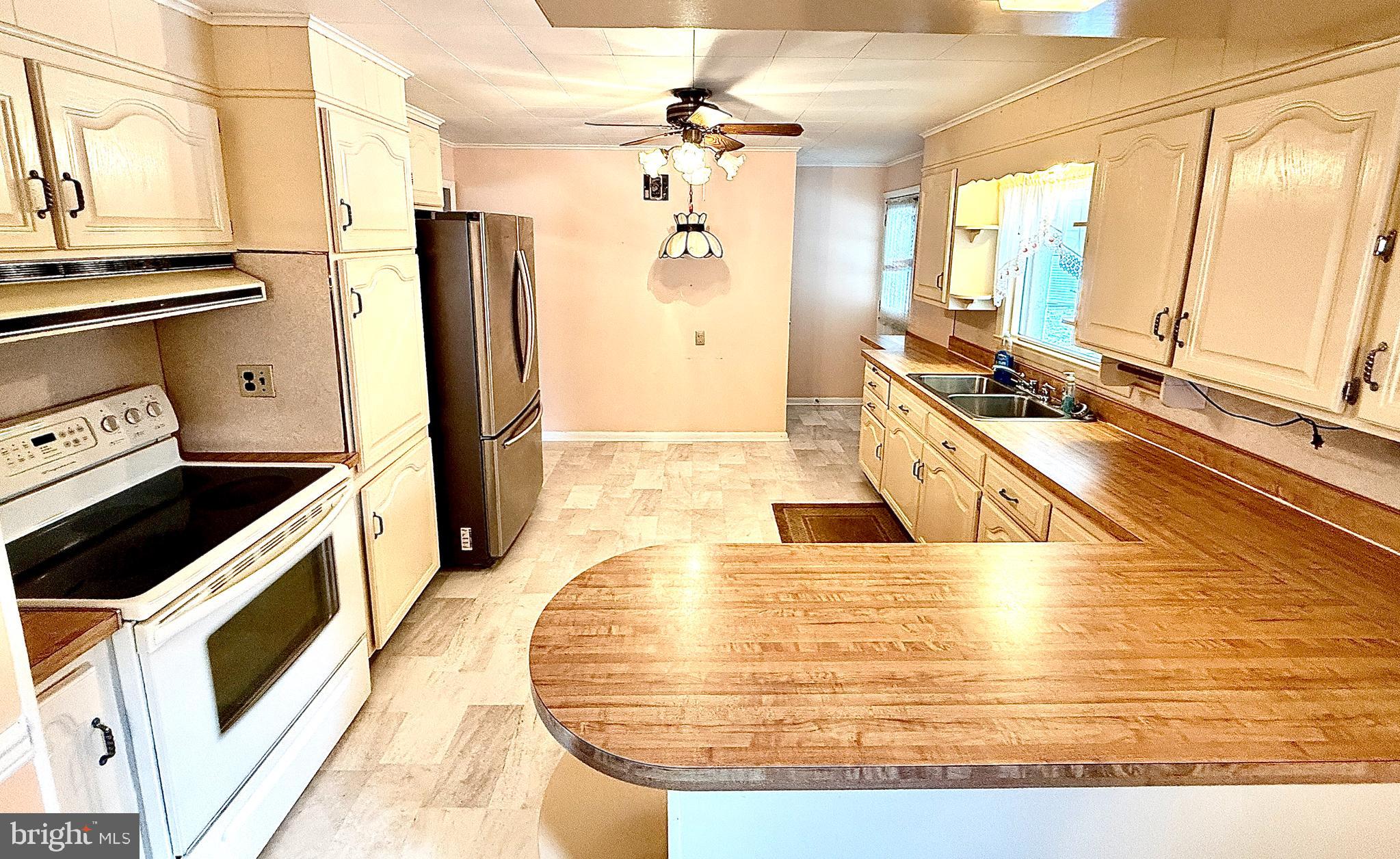 320 South Bonsall Road Coatesville, PA 19320 - Photo 18 of 36 a view of a kitchen with kitchen island a large counter top space a sink stainless steel appliances and cabinets