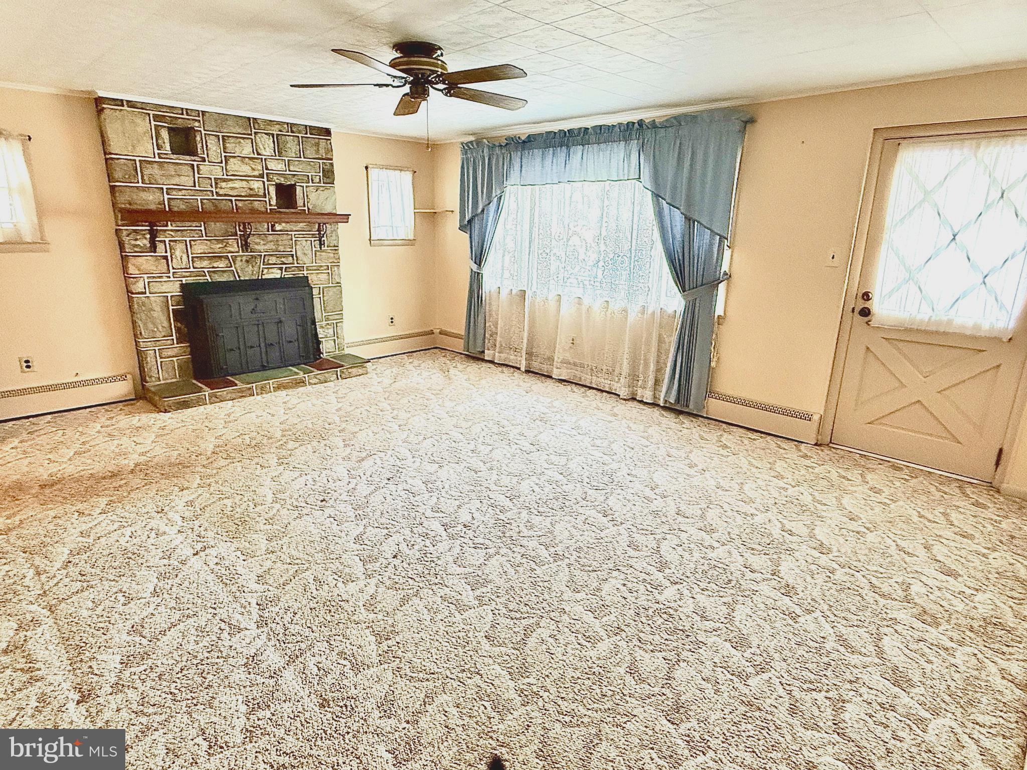 320 South Bonsall Road Coatesville, PA 19320 - Photo 7 of 36 an empty room with fireplace and windows