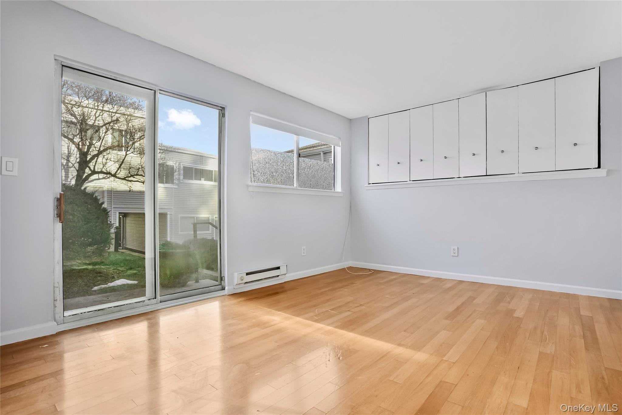 208 Harris Road, Unit HA3 Bedford, NY 10507 - Photo 13 of 41 Empty room with light wood finished floors and a baseboard heating unit