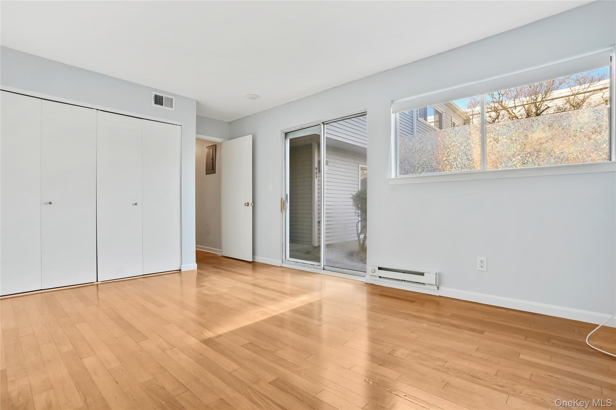 208 Harris Road, Unit HA3 Bedford, NY 10507 - Photo 16 of 41 Unfurnished bedroom with light wood-style flooring, a baseboard heating unit, and a closet