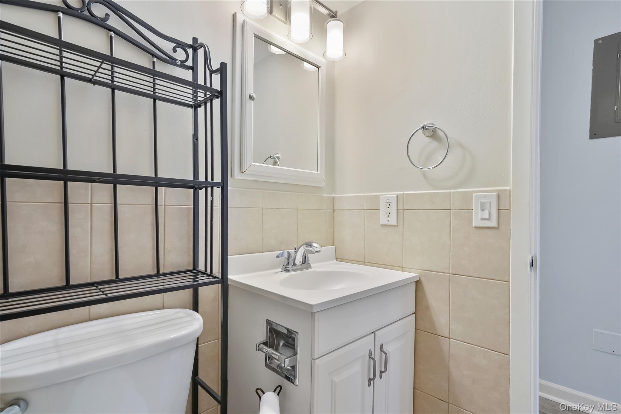 208 Harris Road, Unit HA3 Bedford, NY 10507 - Photo 18 of 41 Half bathroom with vanity, tile walls, and electric panel