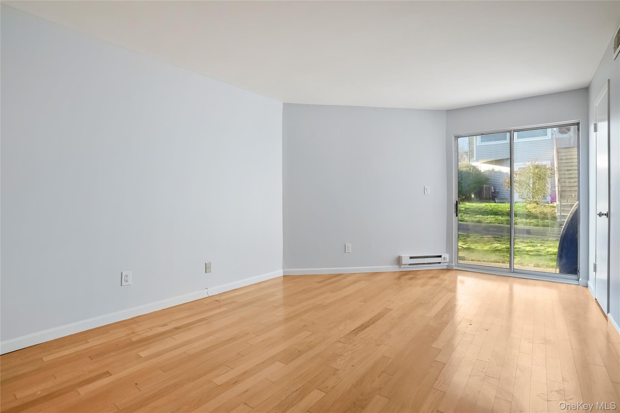 208 Harris Road, Unit HA3 Bedford, NY 10507 - Photo 19 of 41 Empty room with wood-type flooring and a baseboard radiator