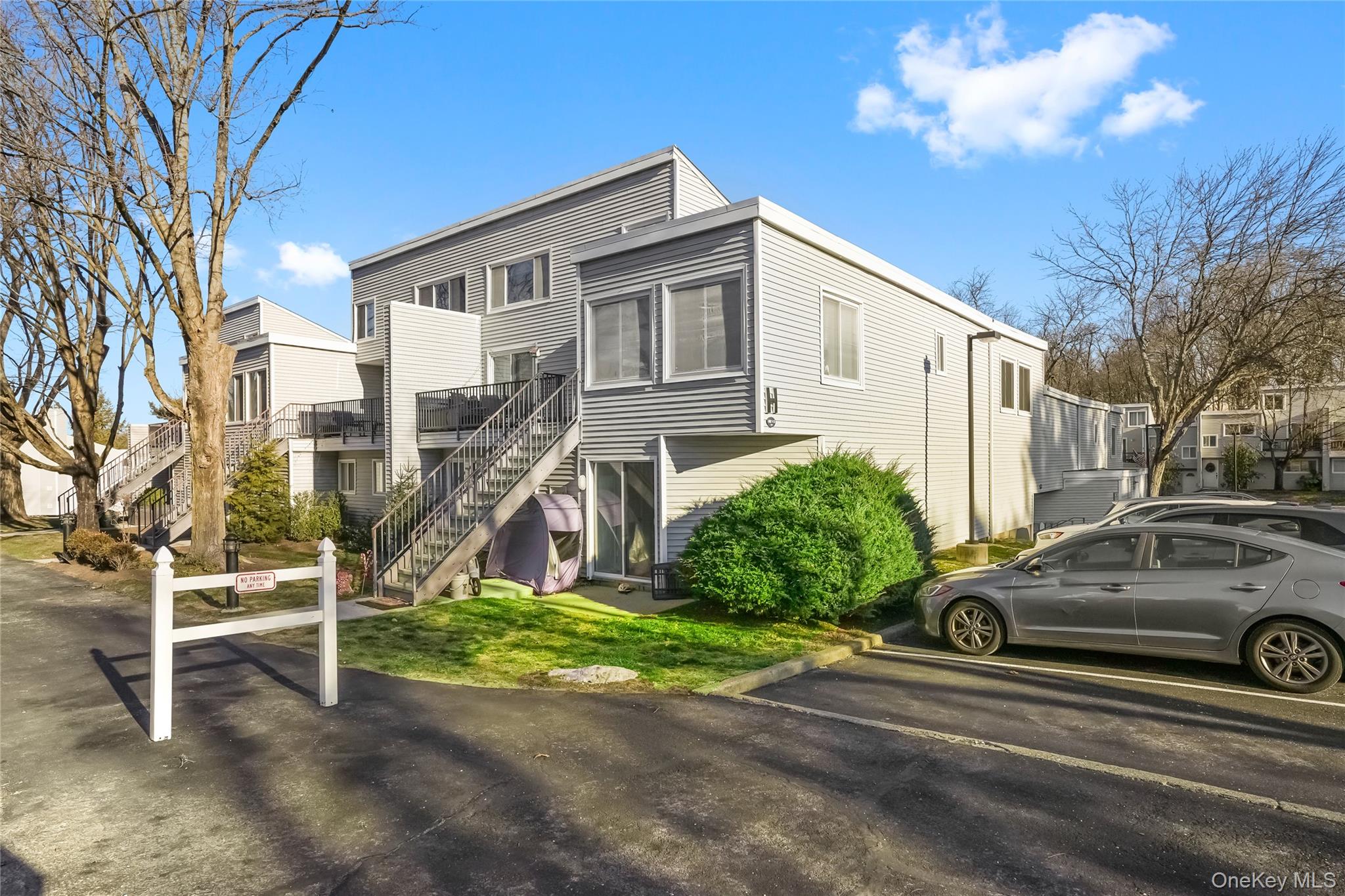 208 Harris Road, Unit HA3 Bedford, NY 10507 - Photo 2 of 41 View of front of home featuring stairs, uncovered parking, and a front lawn