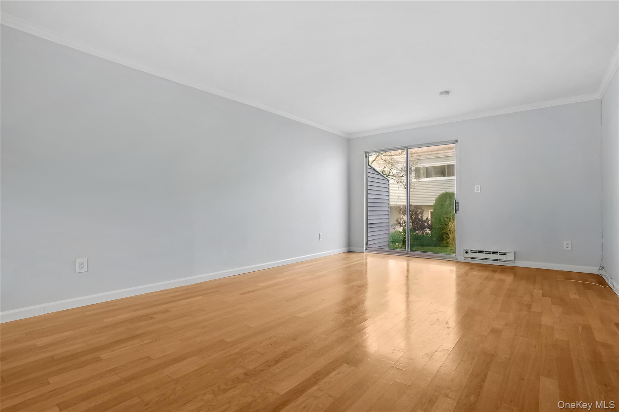 208 Harris Road, Unit HA3 Bedford, NY 10507 - Photo 27 of 41 Unfurnished room with light wood-style flooring, crown molding, and a baseboard radiator