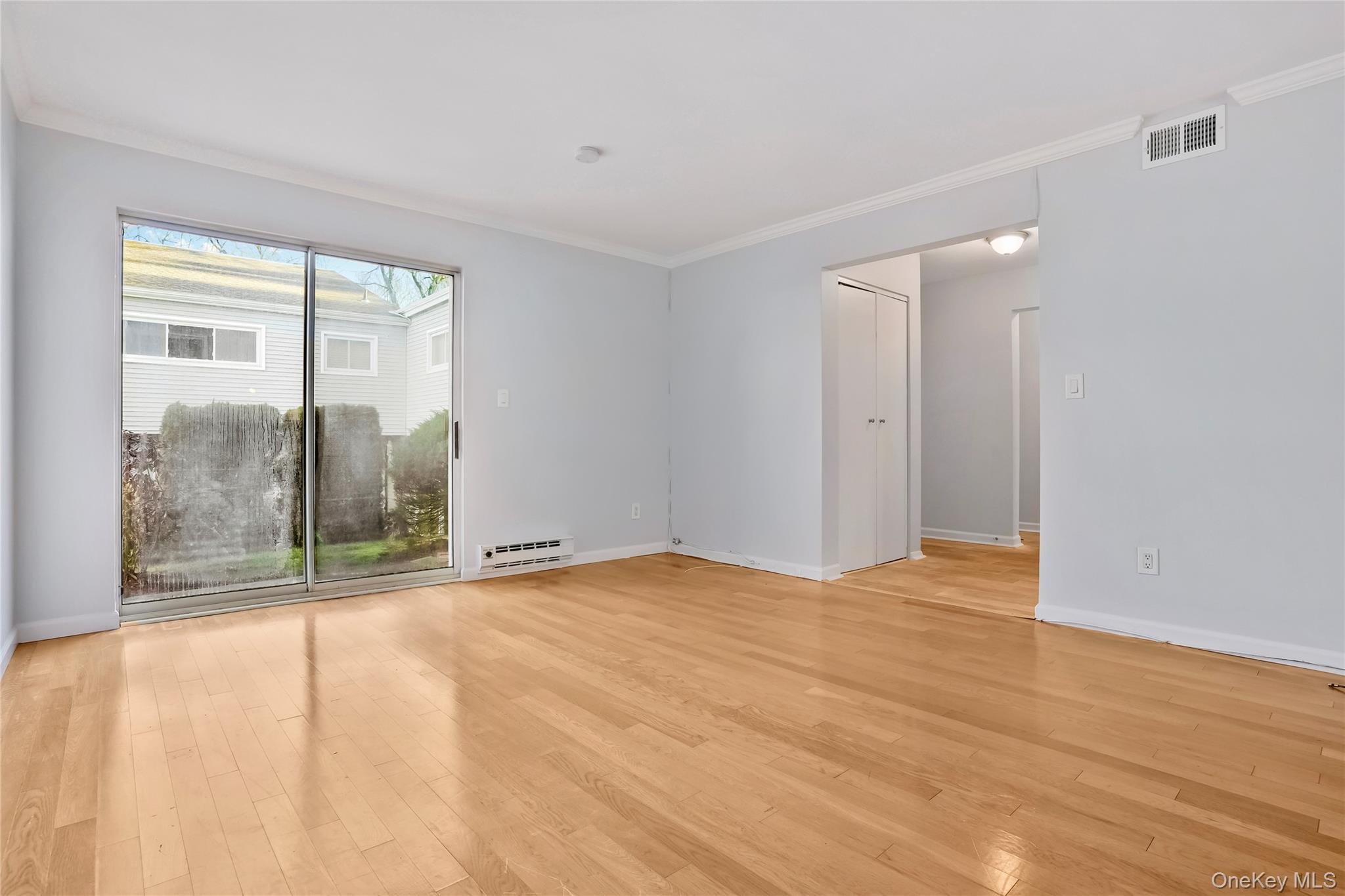 208 Harris Road, Unit HA3 Bedford, NY 10507 - Photo 28 of 41 Empty room with crown molding, light wood finished floors, and a baseboard radiator
