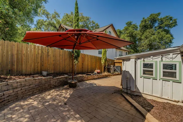 a view of a backyard with table and chairs under an umbrella