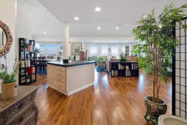 a kitchen with stainless steel appliances kitchen island granite countertop a stove and a wooden floors