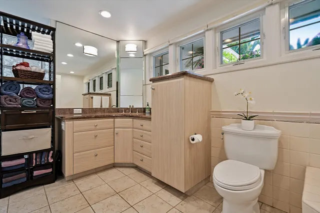 a bathroom with a granite countertop toilet sink and mirror