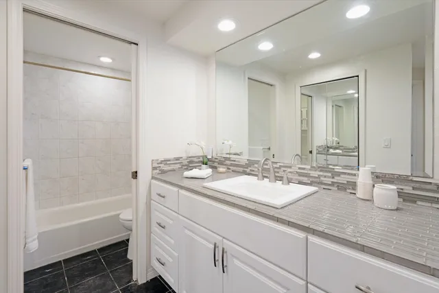 a bathroom with a sink double vanity granite tub and shower