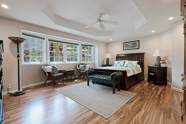 a bedroom with a bed wooden floor and windows